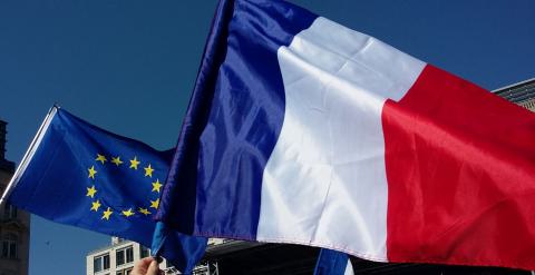 Le drapeau de la France au premier plan, accompagné du drapeau de l'UE